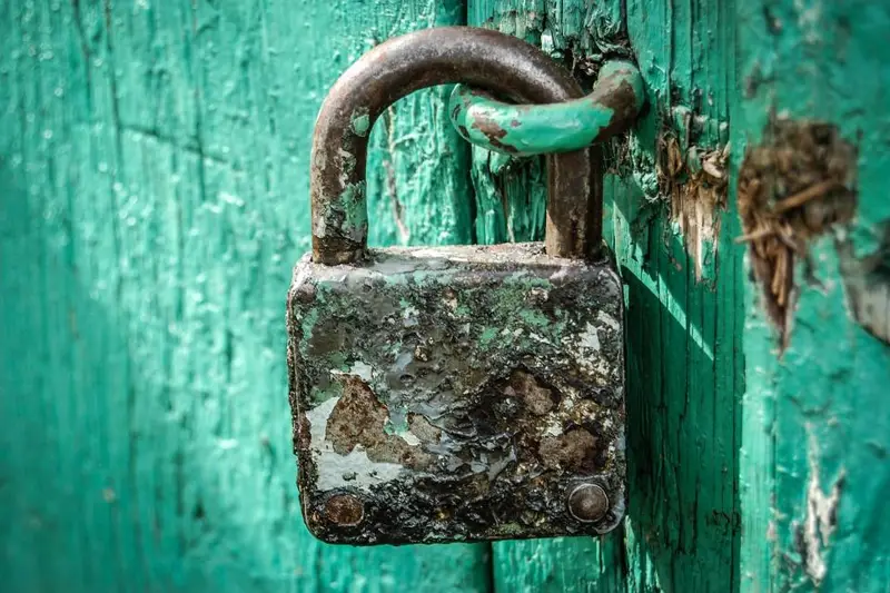 Candado oxidado en una puerta verde