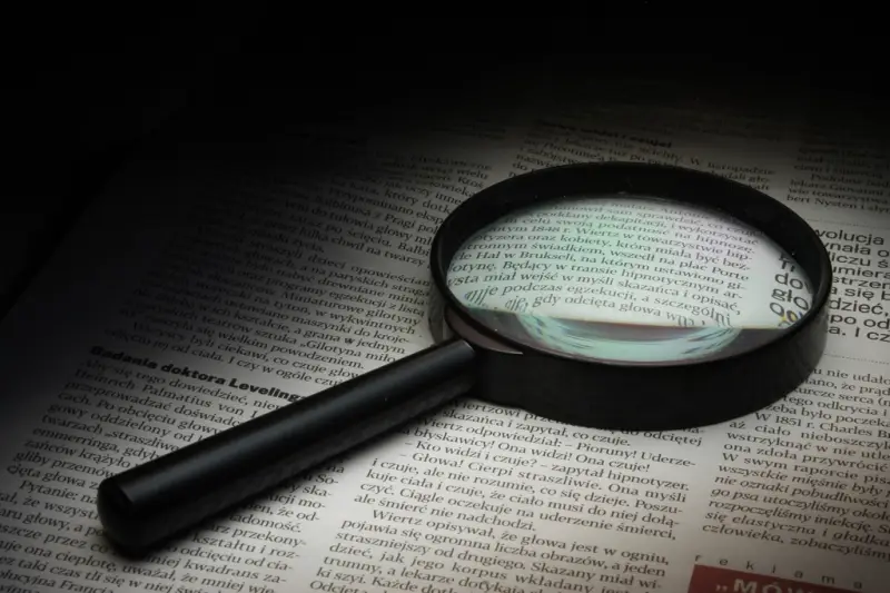 Lupa sobre las páginas de un periódico