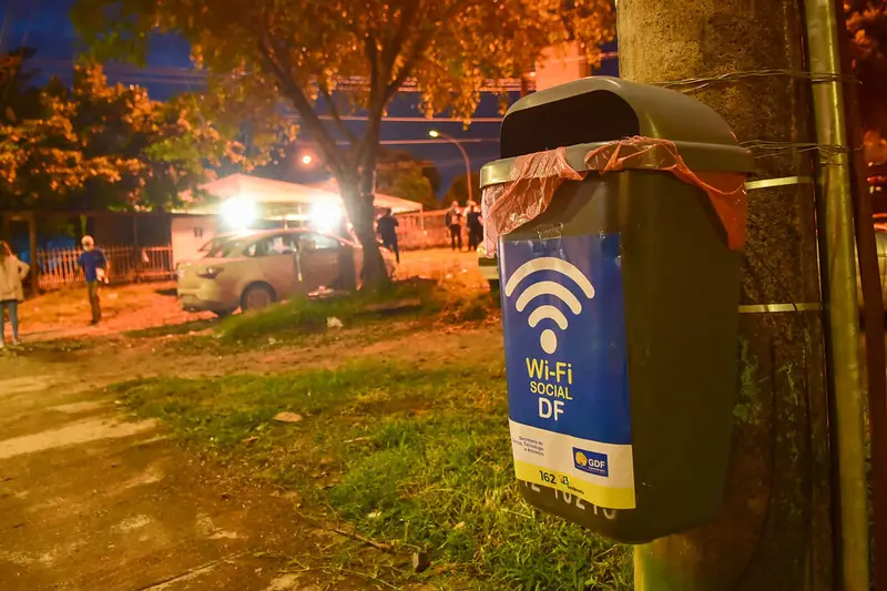 Cartel de zona Wi-Fi gratuita en un poste por la noche