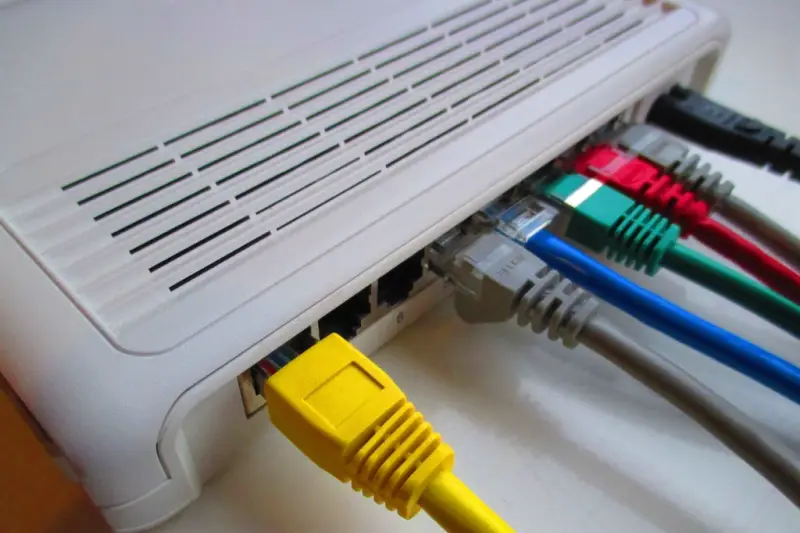 Cables de red de colores conectados a la parte trasera de un router