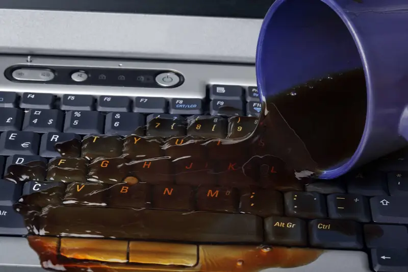 Café derramado sobre el teclado de un portátil