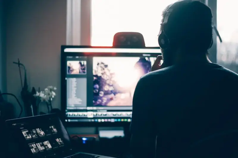 Persona frente a un monitor en una habitación a oscuras