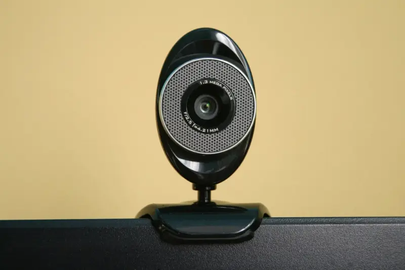 Webcam redonda colocada sobre el borde de un monitor