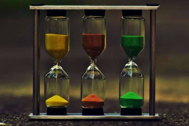 Tres relojes de arena con arena de colores