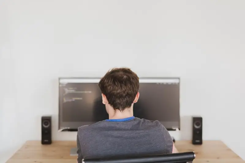 Persona programando frente a un monitor en un escritorio