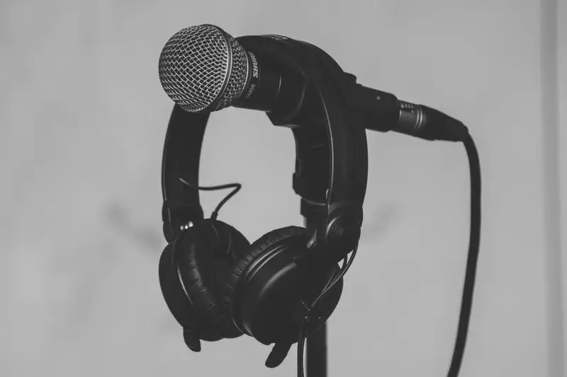 Auriculares colgados de un micrófono en su soporte
