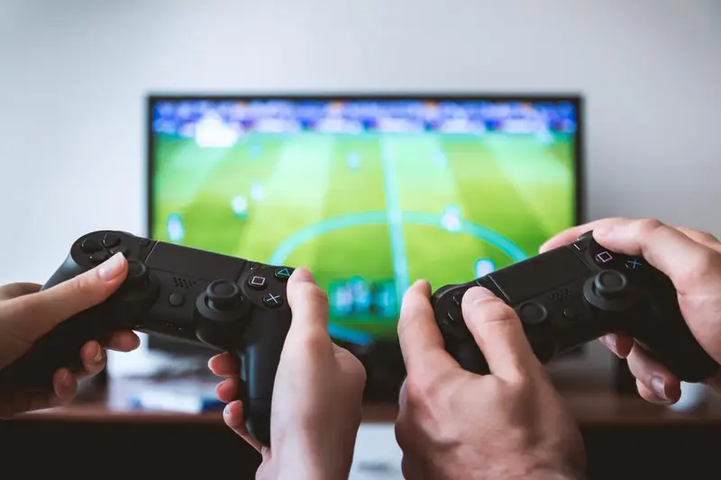 Dos personas jugando con mandos delante de un televisor