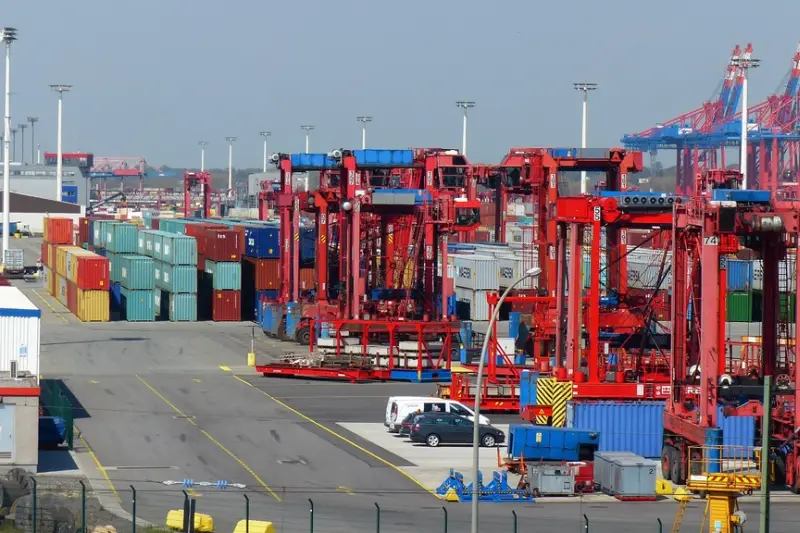 Puerto con grúas y contenedores de carga apilados