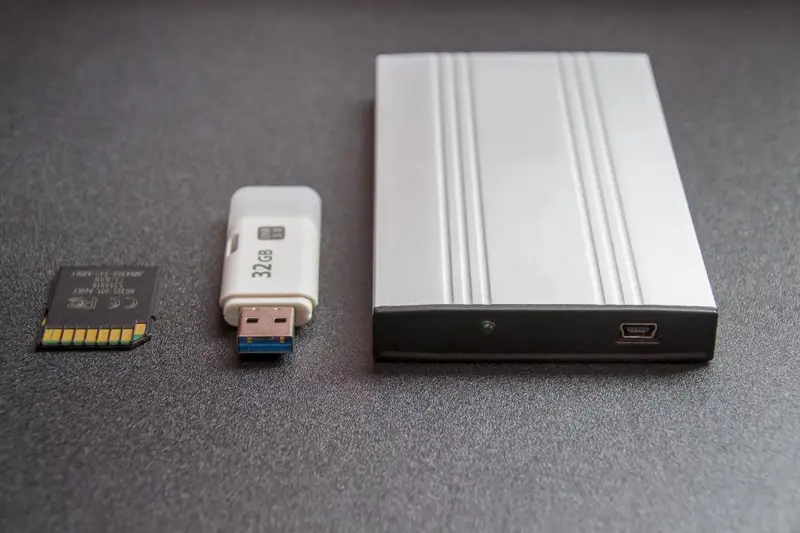 Disco duro externo junto a una memoria USB y una tarjeta de memoria
