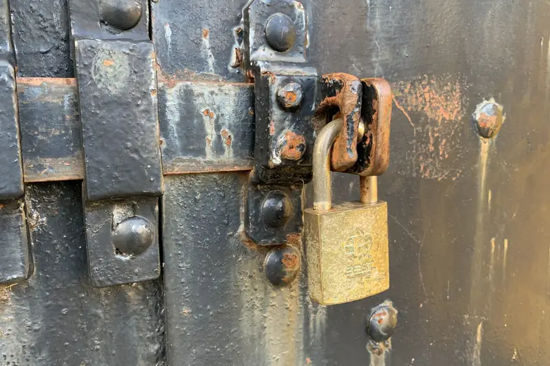 Candado cerrando el pestillo de una puerta metálica