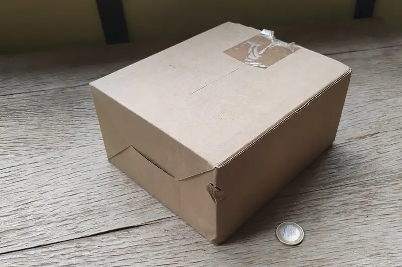 Caja de cartón cerrada sobre una mesa de madera