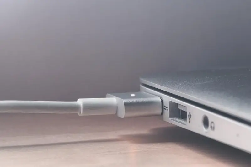 Cable de carga conectado al lateral de un portátil