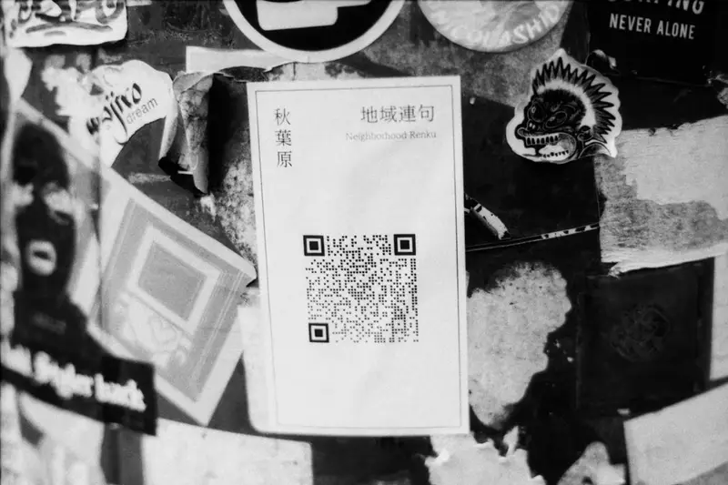 Código QR pegado en una pared llena de pegatinas